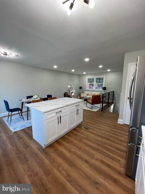 kitchen featuring white cabinets, dark wood-type flooring, and stainless steel refrigerator