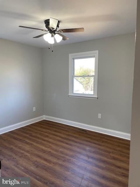 empty room with dark hardwood / wood-style floors and ceiling fan