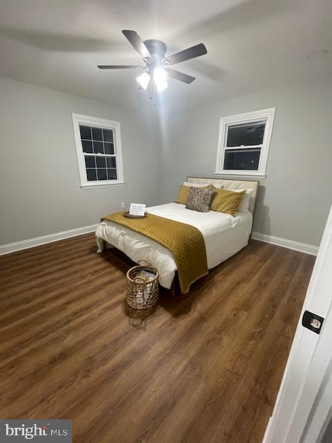 bedroom with dark hardwood / wood-style flooring and ceiling fan