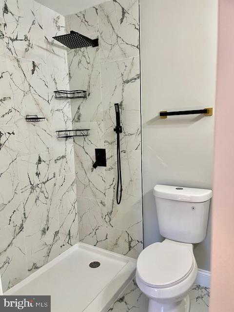 bathroom with toilet and a tile shower