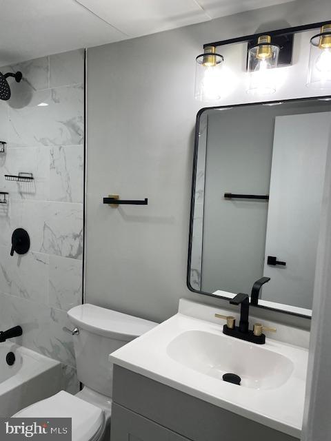 full bathroom with vanity, toilet, and tiled shower / bath