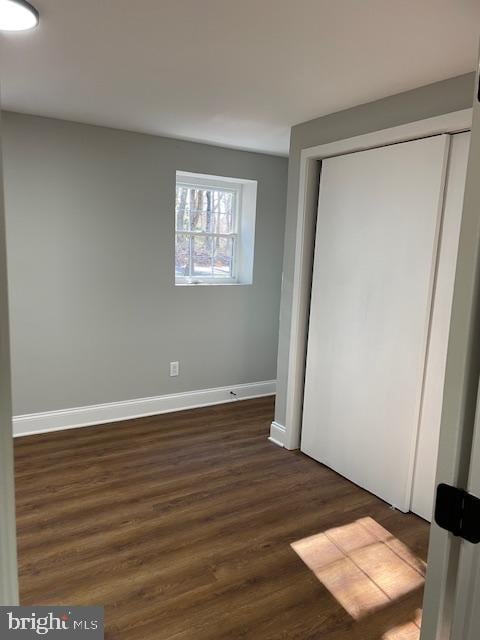 unfurnished bedroom featuring dark hardwood / wood-style flooring and a closet