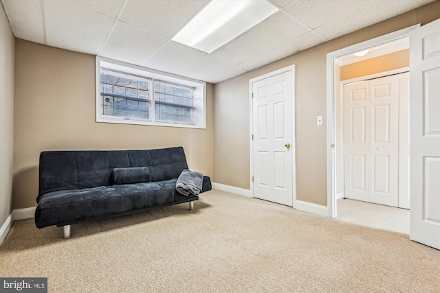 sitting room featuring a paneled ceiling and light carpet