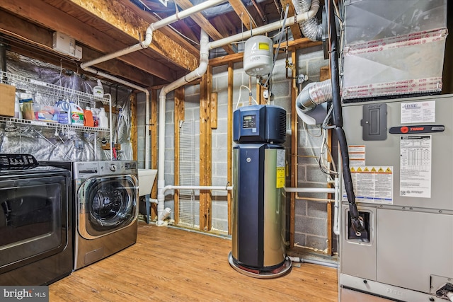 clothes washing area featuring washer and dryer, hardwood / wood-style floors, and heating unit