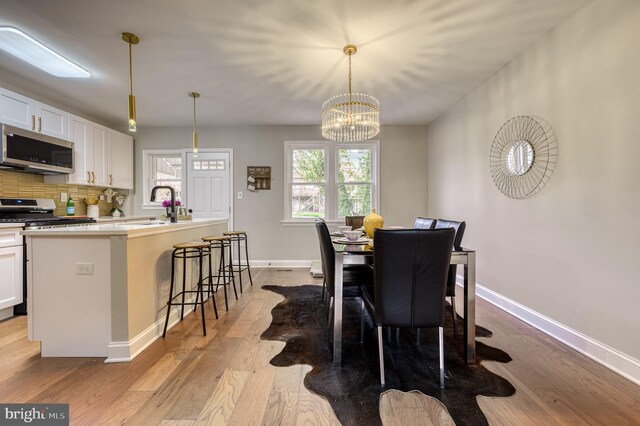 dining room featuring a chandelier, light hardwood / wood-style floors, and sink