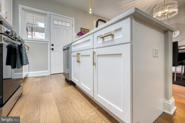 interior space with light hardwood / wood-style floors and an inviting chandelier