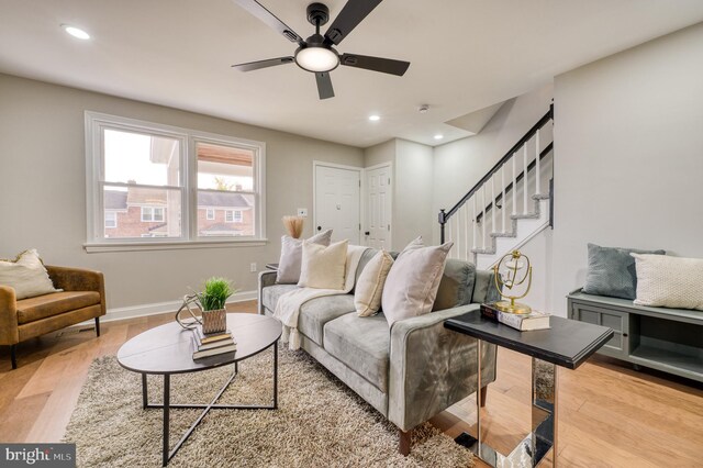 living room with light wood-type flooring and ceiling fan