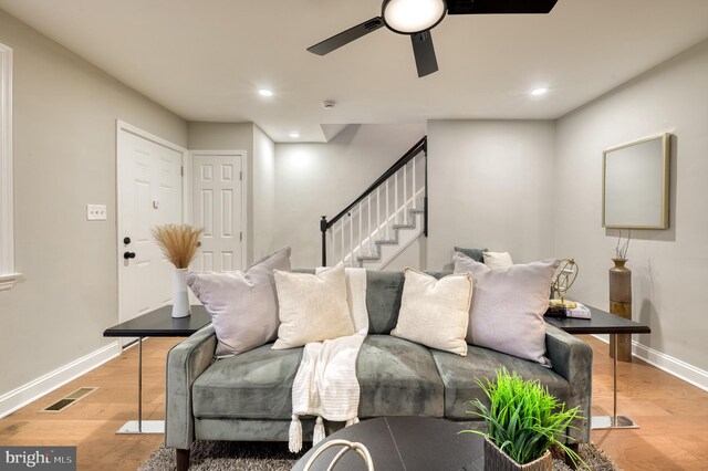 living room featuring ceiling fan and light hardwood / wood-style floors