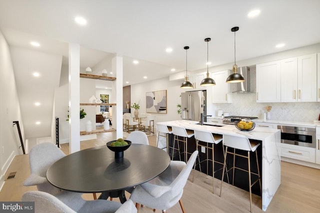 dining space with sink and light hardwood / wood-style flooring