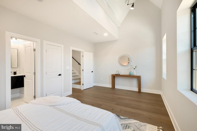 bedroom featuring connected bathroom, hardwood / wood-style flooring, and lofted ceiling