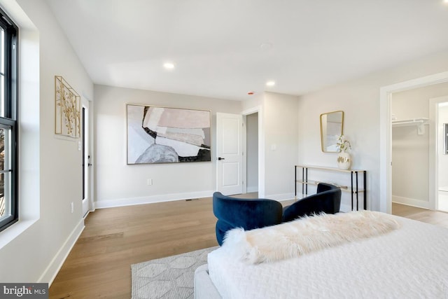 bedroom with a closet, a spacious closet, and light hardwood / wood-style flooring