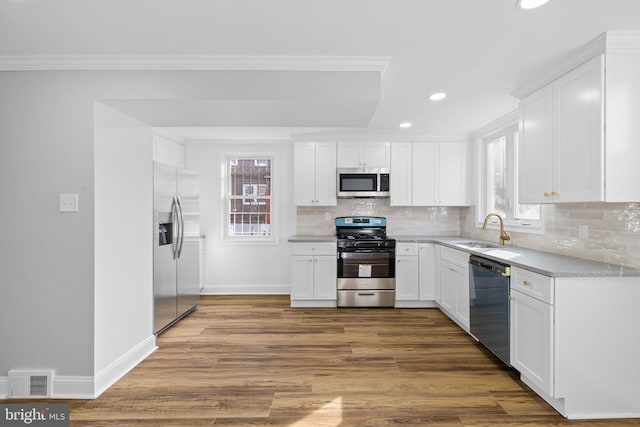 kitchen featuring white cabinets, appliances with stainless steel finishes, dark hardwood / wood-style floors, and sink