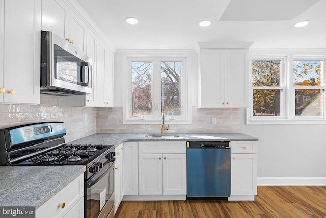 kitchen featuring appliances with stainless steel finishes, white cabinetry, and light hardwood / wood-style flooring