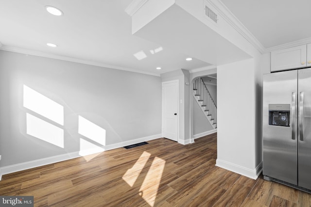 interior space featuring white cabinets, stainless steel fridge, ornamental molding, and dark wood-type flooring