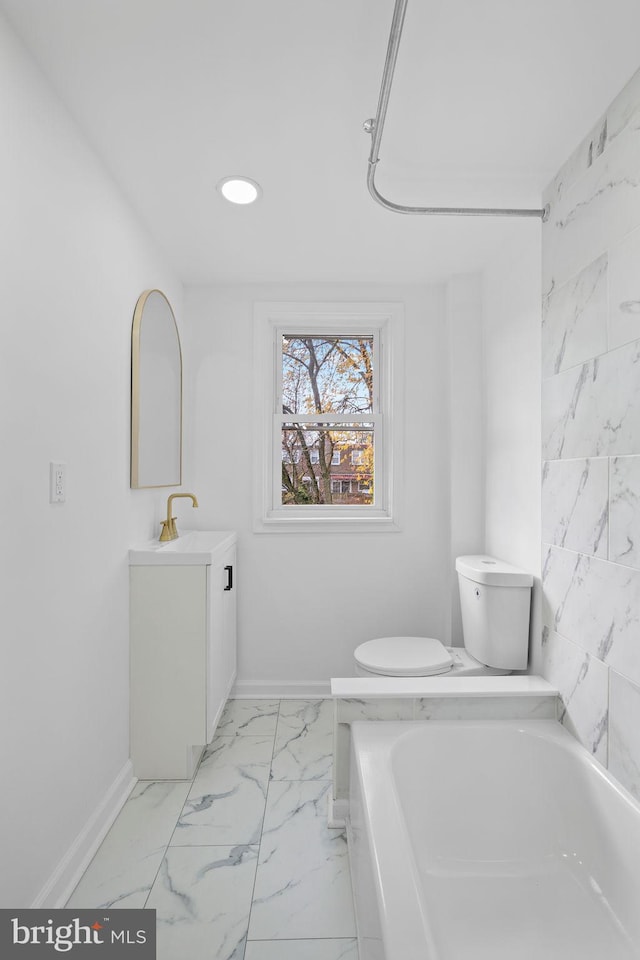 bathroom with a bath, vanity, and toilet