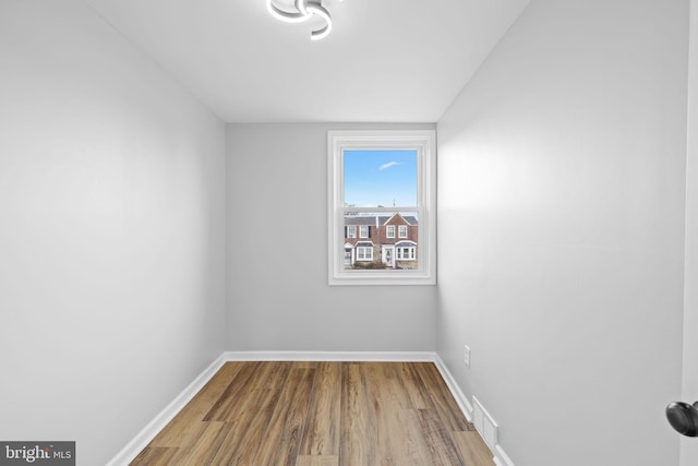 unfurnished room featuring hardwood / wood-style flooring and lofted ceiling