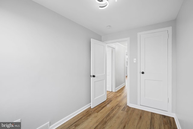 hallway with hardwood / wood-style flooring