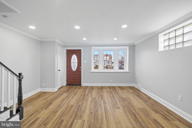 foyer entrance with light hardwood / wood-style floors and ornamental molding