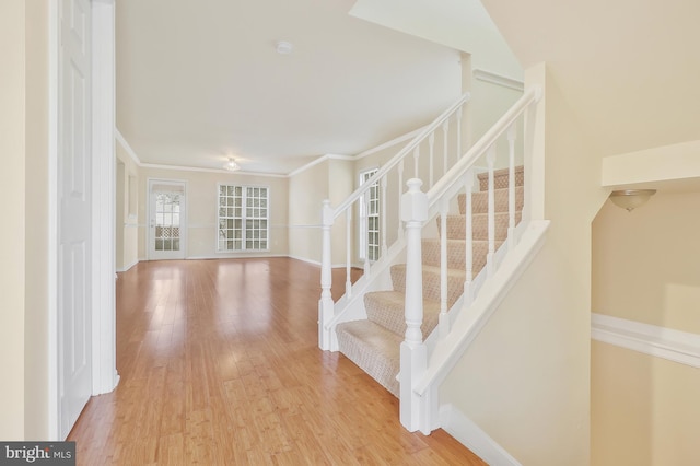 stairway featuring hardwood / wood-style floors and crown molding