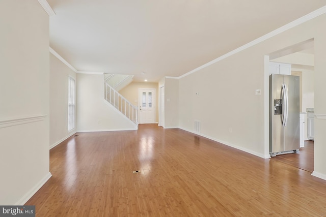 unfurnished living room with light hardwood / wood-style floors and crown molding