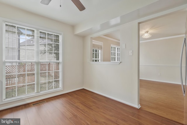 spare room featuring hardwood / wood-style floors, ceiling fan, and ornamental molding