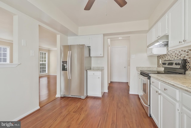 kitchen featuring light stone countertops, tasteful backsplash, light hardwood / wood-style flooring, white cabinets, and appliances with stainless steel finishes