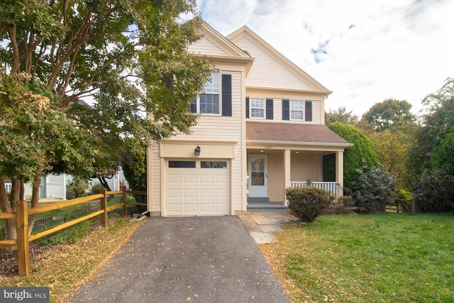 view of front of property with a front yard, a porch, and a garage