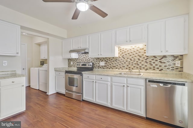 kitchen with stainless steel appliances, white cabinetry, washer and clothes dryer, and sink