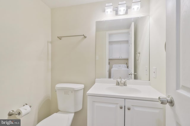 bathroom with vanity, washer / clothes dryer, and toilet