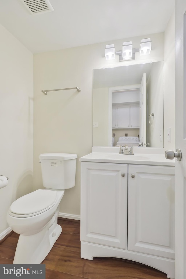 bathroom with hardwood / wood-style floors, vanity, and toilet