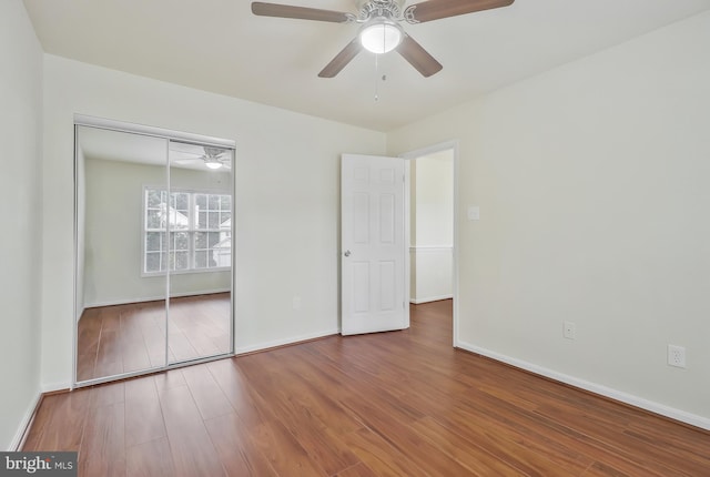 unfurnished bedroom with ceiling fan, a closet, and hardwood / wood-style flooring