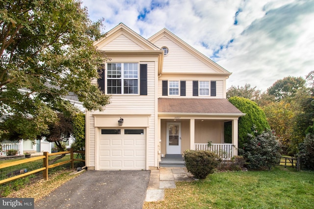 view of front of house featuring covered porch, a garage, and a front yard