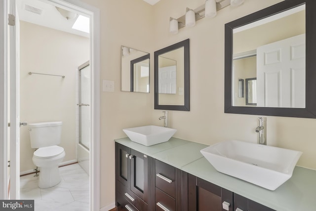 full bathroom featuring shower / bath combination with glass door, vanity, and toilet