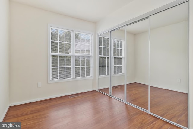 unfurnished bedroom featuring hardwood / wood-style flooring and a closet