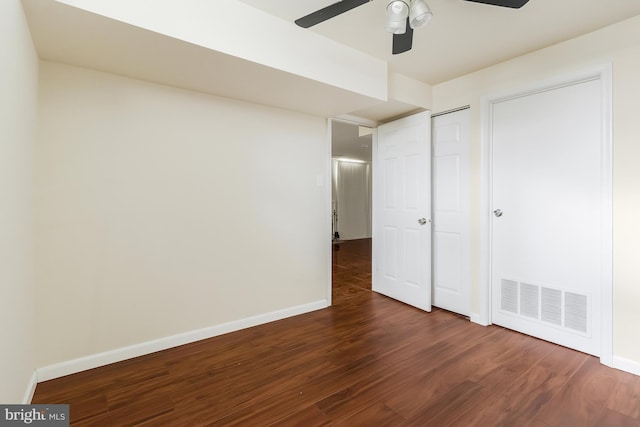 unfurnished bedroom with ceiling fan and dark hardwood / wood-style flooring