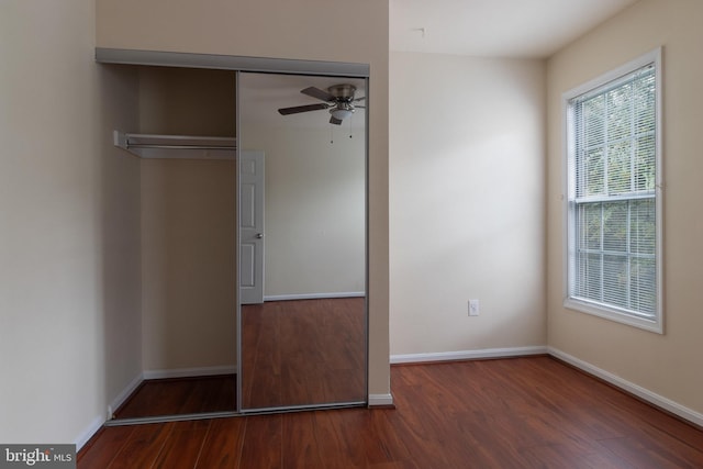 unfurnished bedroom featuring a closet, ceiling fan, and dark hardwood / wood-style flooring