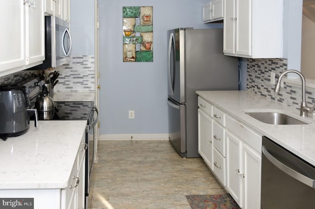 kitchen featuring backsplash, white cabinetry, sink, and stainless steel appliances