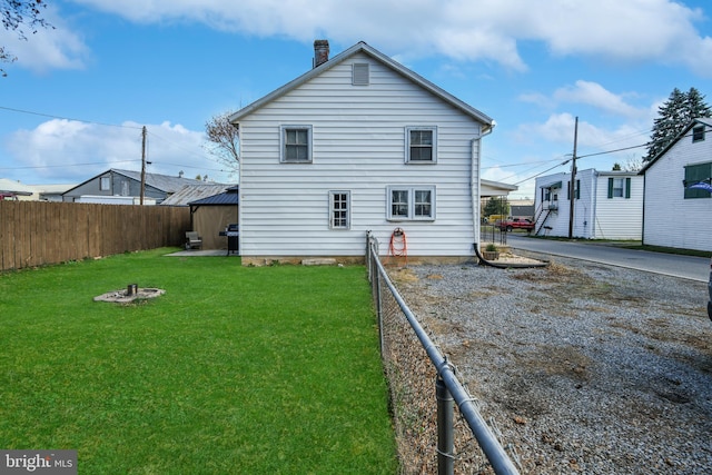 rear view of property featuring a lawn