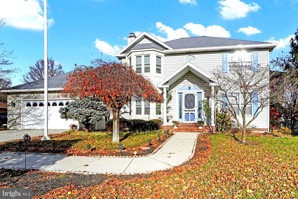 front facade featuring a garage and a front lawn