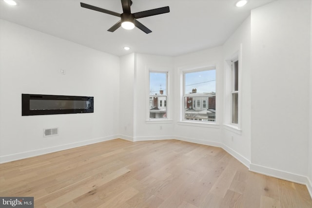 empty room with ceiling fan and light wood-type flooring