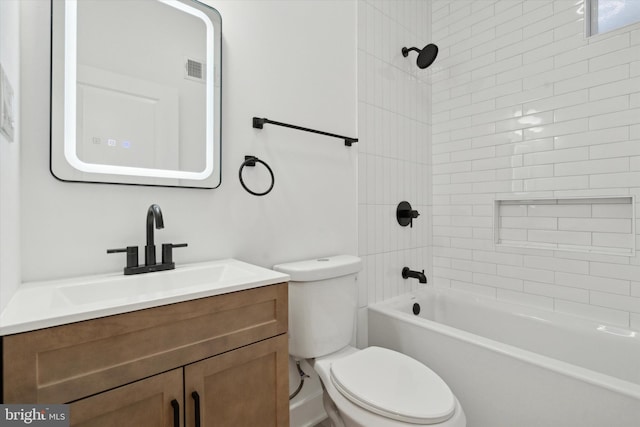 full bathroom with vanity, tiled shower / bath combo, and toilet