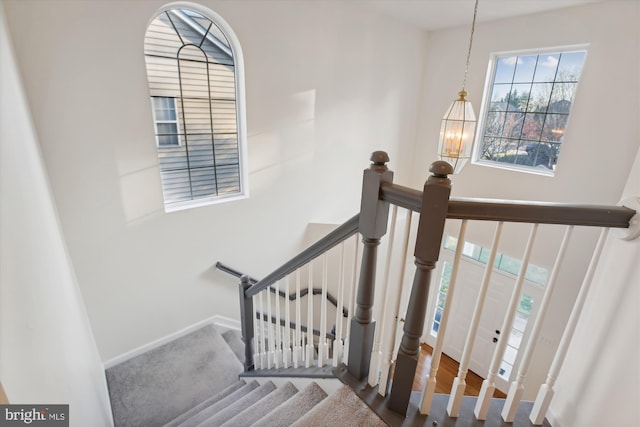 stairway featuring an inviting chandelier