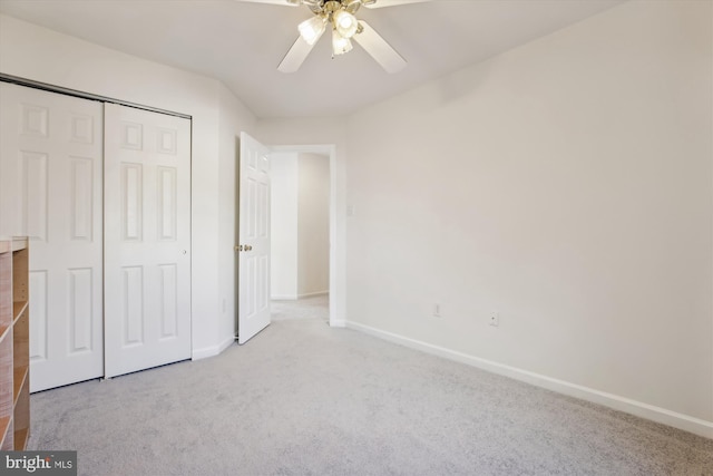 unfurnished bedroom with ceiling fan, light colored carpet, and a closet