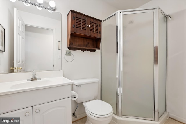 bathroom featuring vanity, toilet, and a shower with shower door