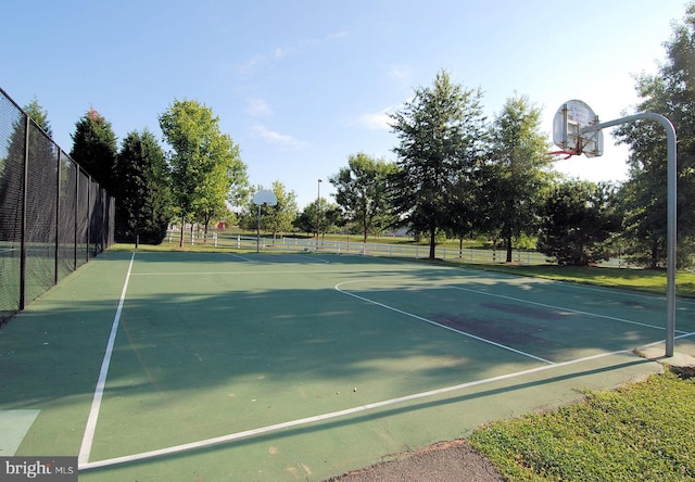 view of tennis court featuring basketball hoop