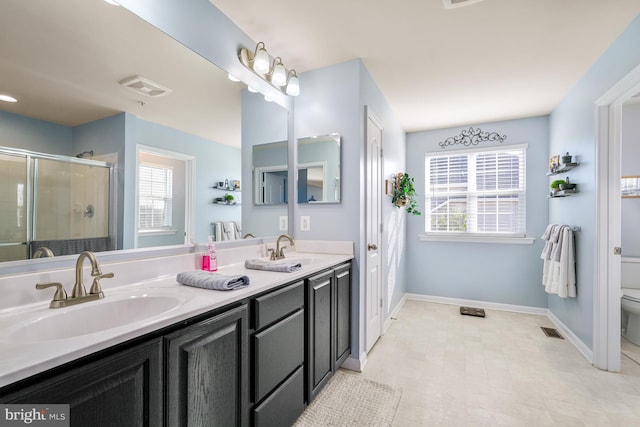 bathroom with toilet, a wealth of natural light, an enclosed shower, and vanity