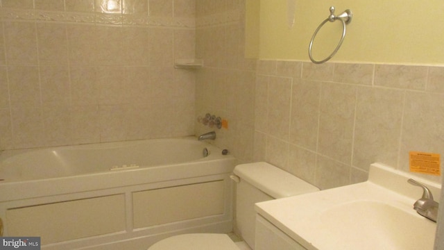 bathroom featuring toilet, tile walls, and tiled shower / bath