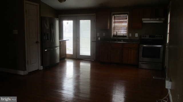 kitchen with stainless steel refrigerator with ice dispenser, range with electric cooktop, dark hardwood / wood-style flooring, and plenty of natural light