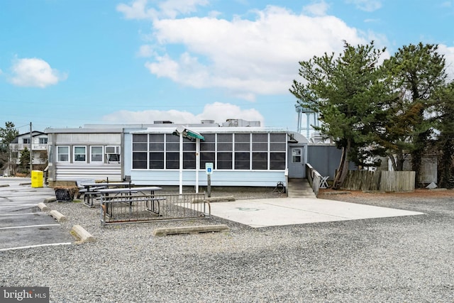 rear view of house featuring a sunroom