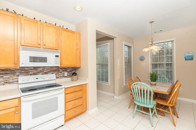 kitchen featuring a chandelier, decorative backsplash, white appliances, and hanging light fixtures